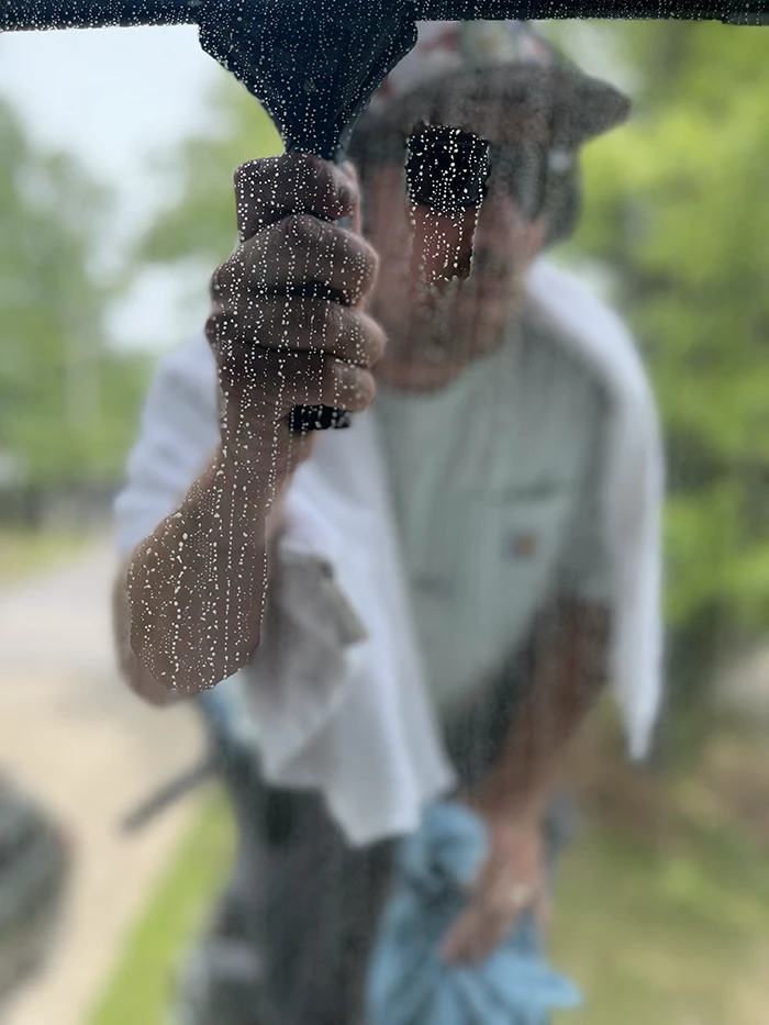 Landon finishing a window with a squeegee
